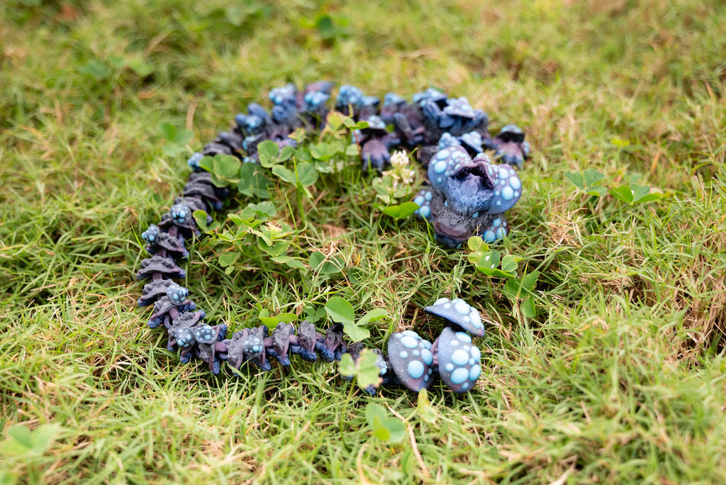 Blue and purple toy dragon on grass