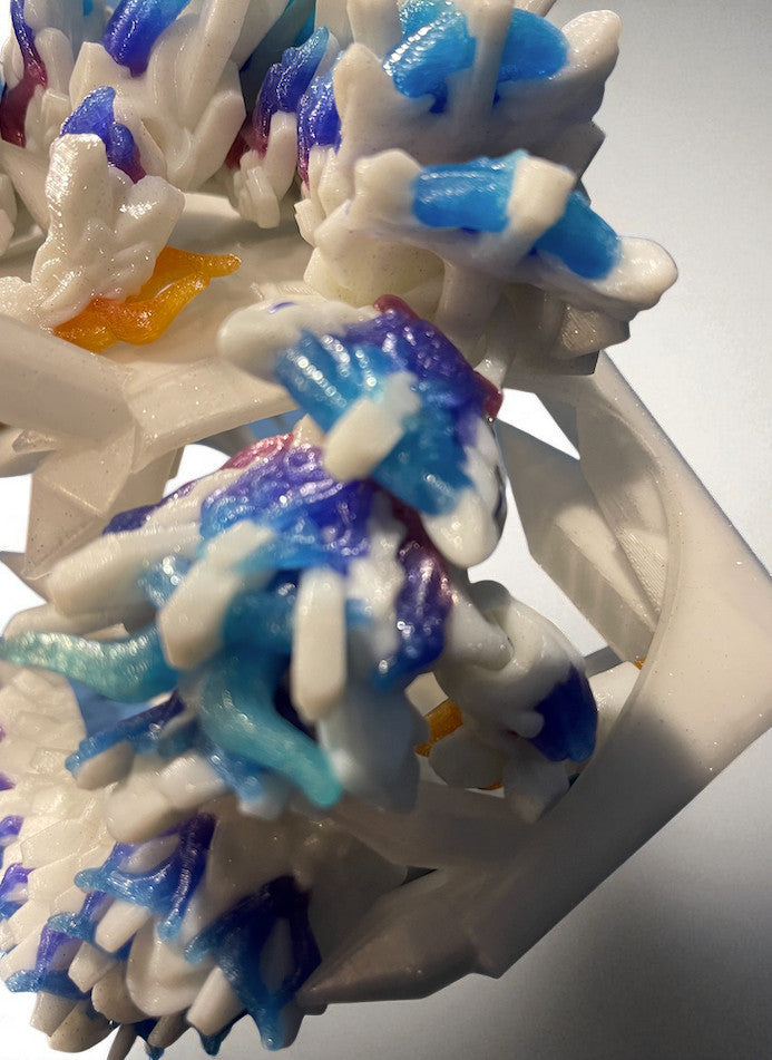 Close-up of a colorful 3D-printed object with white, blue, and purple hues.