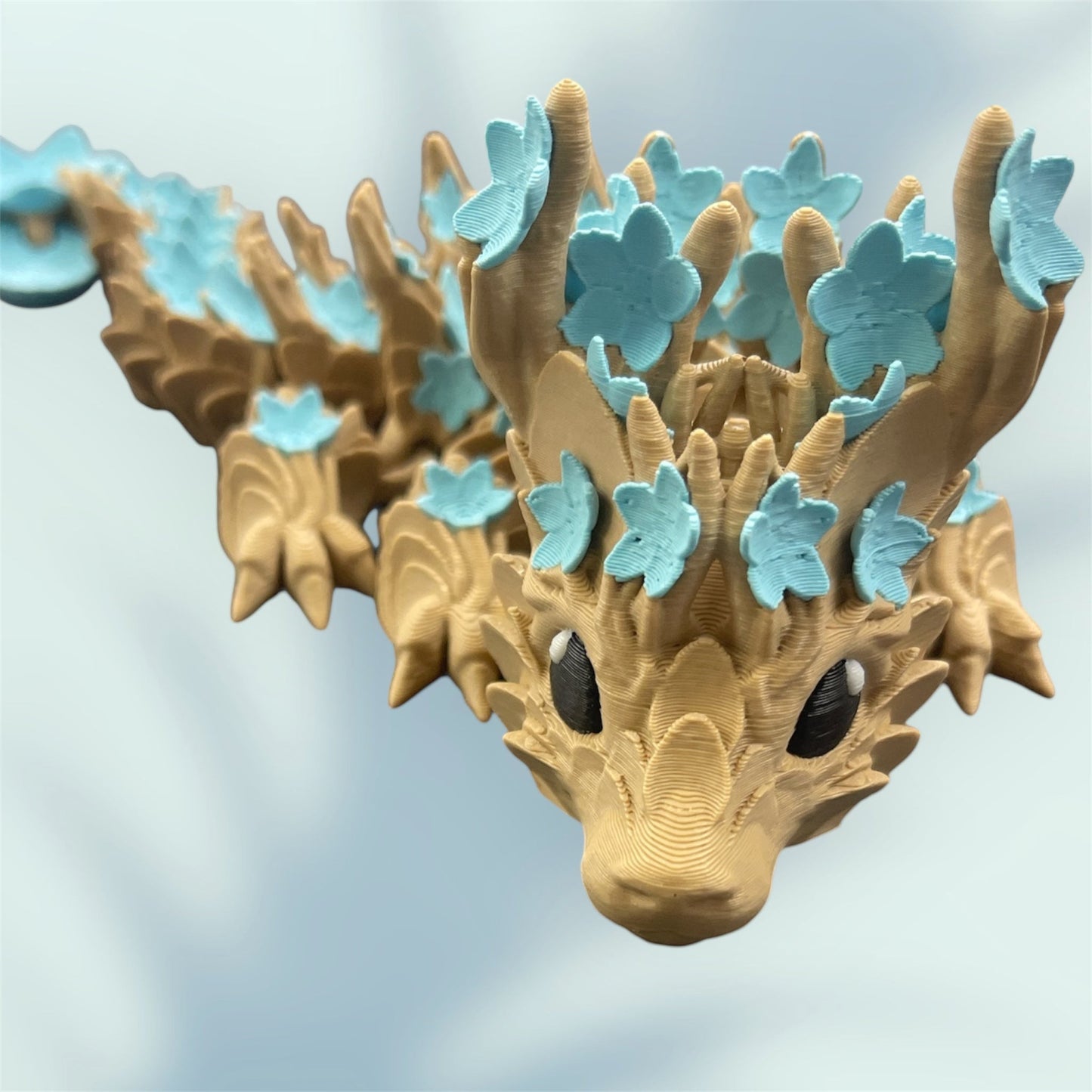 1 Layer At A time Baby Cherry Blossom Dragon figurine with light brown wood-like texture and light blue flowers.