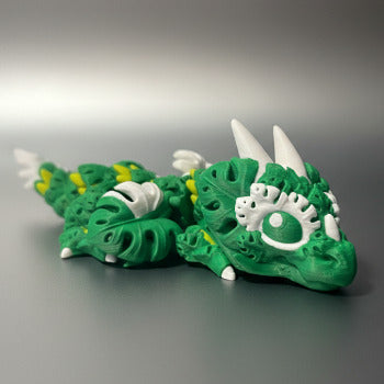 1 Layer At A time Baby Monstera Plant Dragon, a green articulated 3D printed dragon with monstera leaf details and white accents.