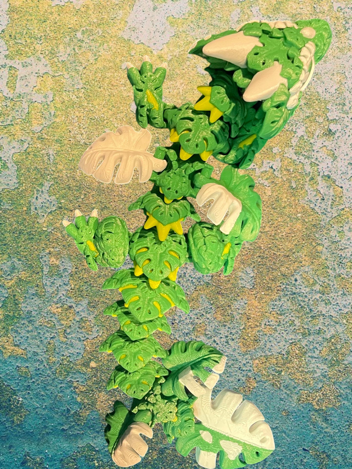 1 Layer At A time Baby Monstera Plant Dragon, a green and white articulated dragon with monstera leaf details and yellow accents.