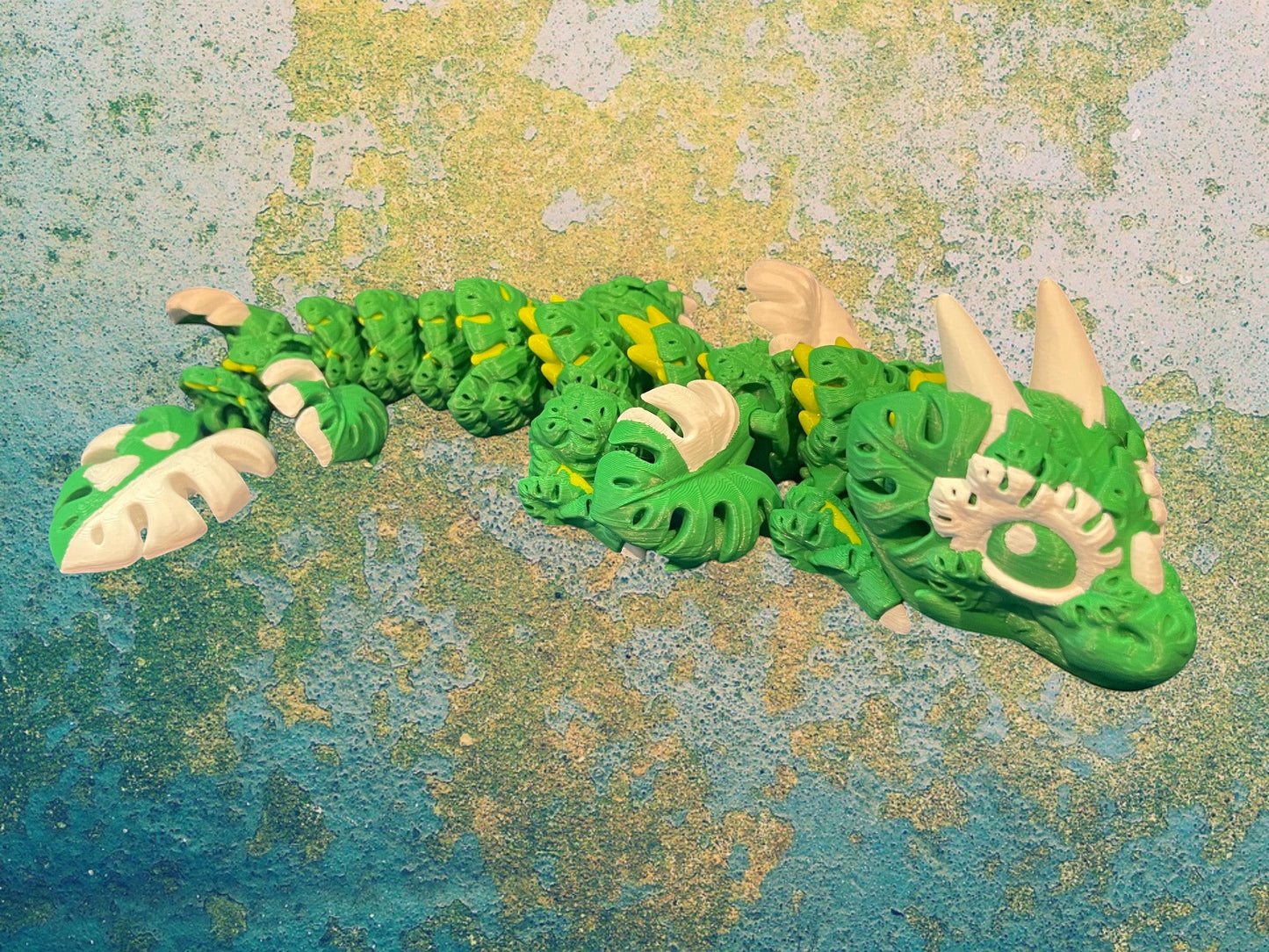 1 Layer At A time Baby Monstera Plant Dragon, a green and white articulated dragon with monstera leaf details.