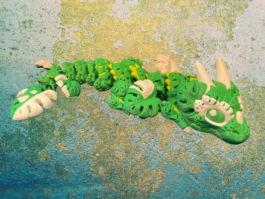 1 Layer At A time Baby Monstera Plant Dragon, a green and white articulated dragon with monstera leaf details.