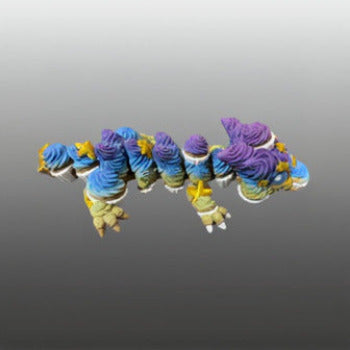 1 Layer At A time articulated cupcake dragon with blue, purple, and yellow frosting details and gold stars.