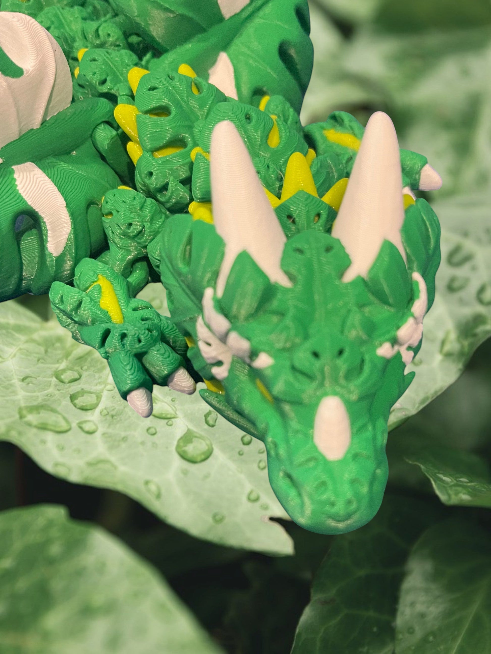 1 Layer At A time Monstera Dragon, a 19-inch articulated fantasy dragon with green, yellow, and white leaf-shaped details, perfect for display or fidgeting.