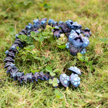 Blue and purple toy dragon on grass