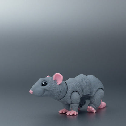Gray toy rat on a stone surface with potted plants in the background